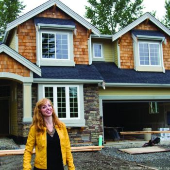 image of CEO Heather standing in front of a home under construction