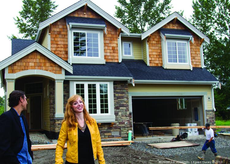 image of CEO Heather standing in front of a home under construction